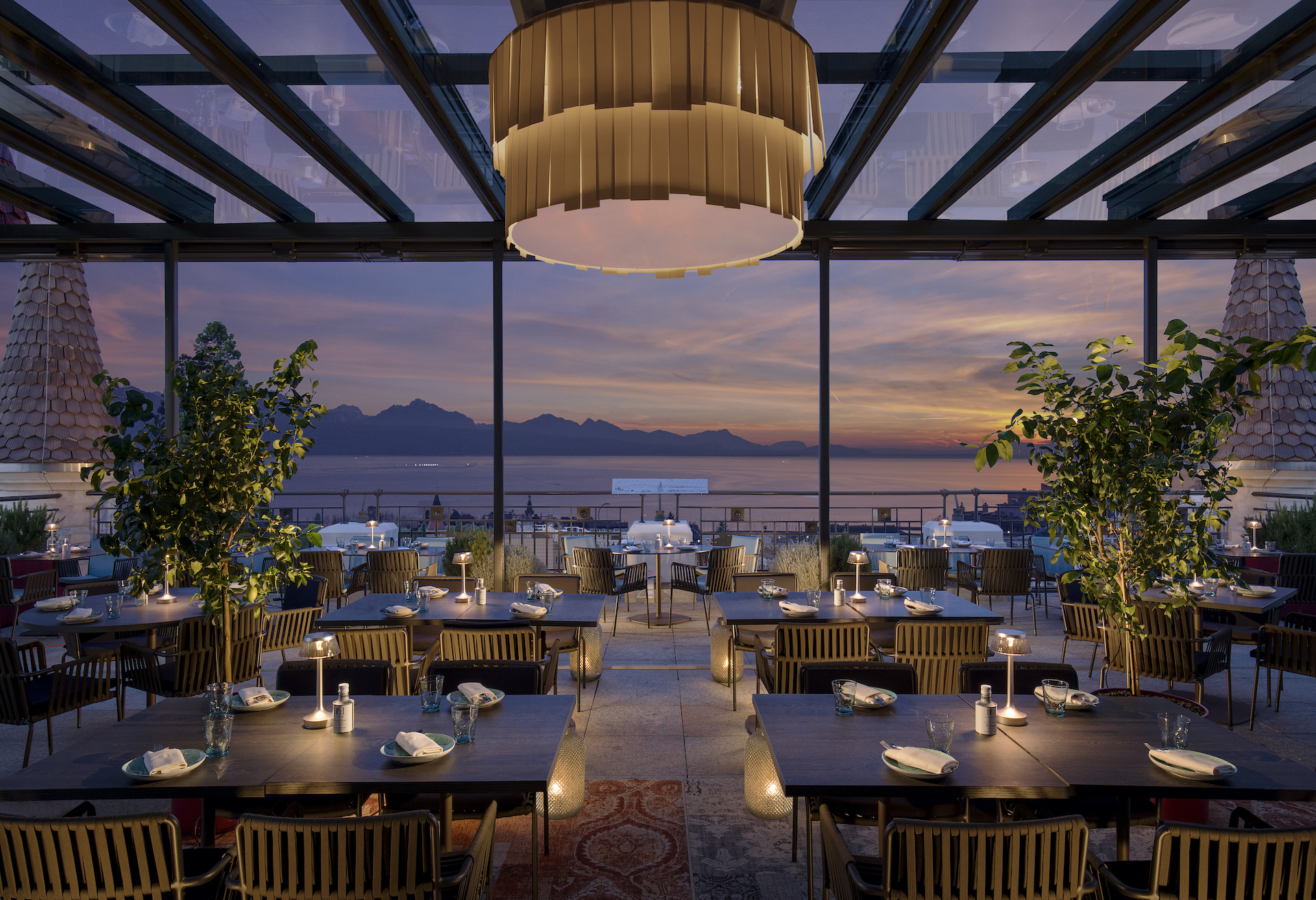 Elegant dining area with warm lighting and panoramic sunset views, capturing a serene and sophisticated atmosphere for diners.