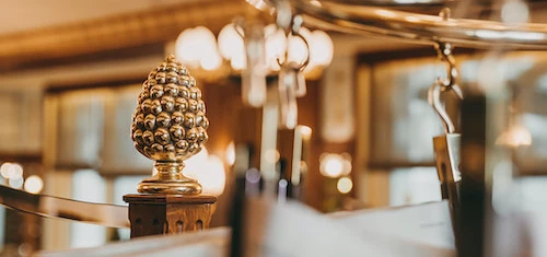 Bustling outdoor market scene with diverse individuals under a grand, castle-like building, captures a lively urban shopping experience.