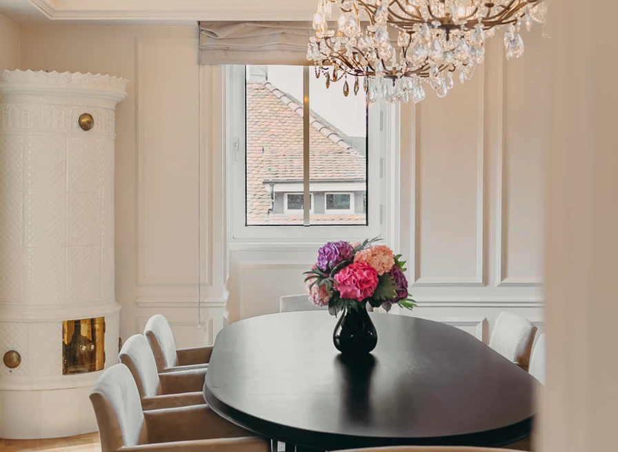 Elegant hotel room with a plush gray headboard and floral-patterned bedding, offering a serene and luxurious atmosphere.