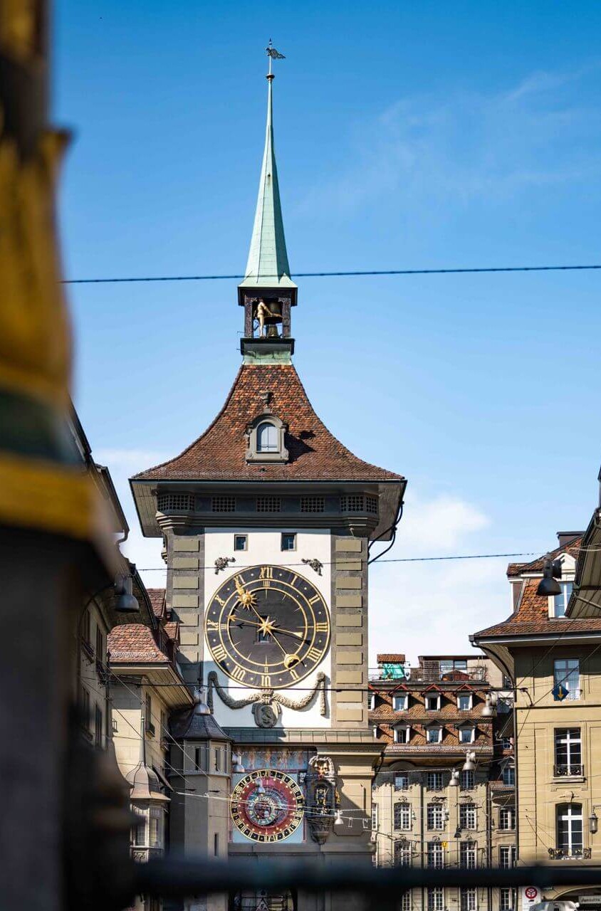 Historic clock tower with intricate gold details, set against a vivid blue sky, invoking a sense of timelessness ideal for history enthusiasts.